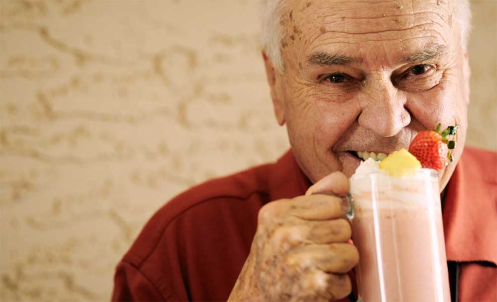 Senior citizen drinking strawberry smoothie